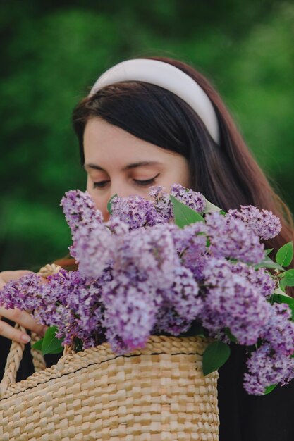 Mooie vrouw poseren met lila bloemen de zomer komt eraan