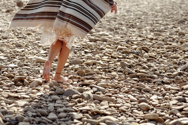 Mooie vrouw reiziger blootsvoets lopen op rivier strand benen close-up boho reizen concept ruimte voor tekst