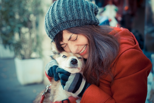 mooie vrouw rode jas knuffelen de hond