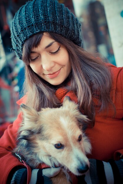 mooie vrouw rode jas knuffelen de hond