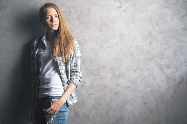 Mooie vrouw tegen betonnen muur