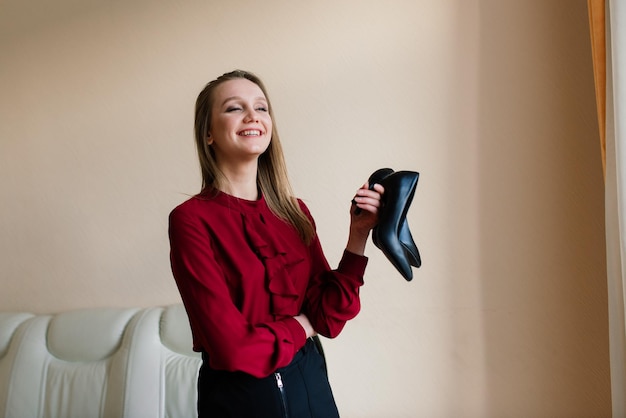 Mooie vrouw thuis met schoenen in haar handen