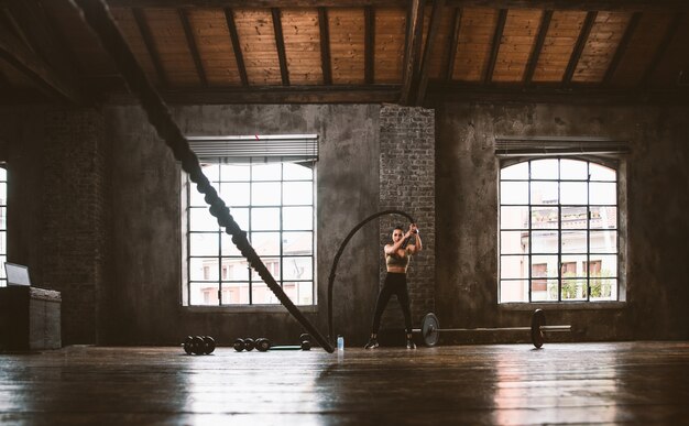 Mooie vrouw traint en maakt functionele training in de sportschool