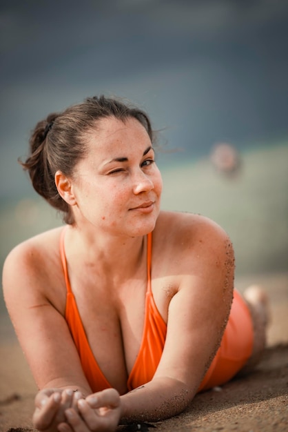 Mooie vrouw van 40 jaar oud op het strand in grote maten zwembroek