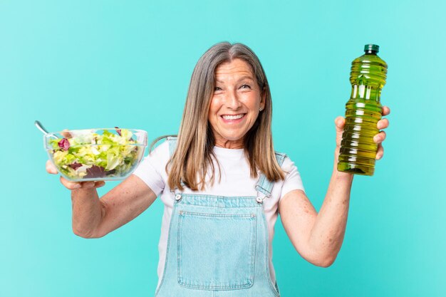 Mooie vrouw van middelbare leeftijd die een salade heeft.