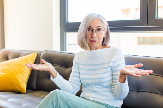 Mooie vrouw van middelbare leeftijd die zich verbaasd en verward voelt