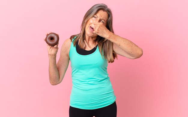 Mooie vrouw van middelbare leeftijd met een donut