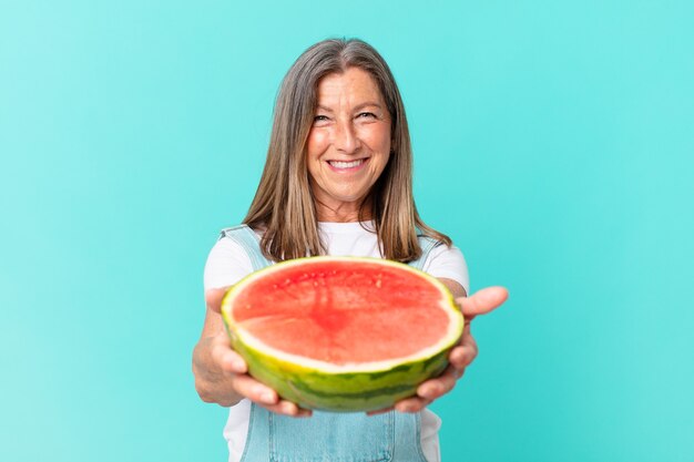 Mooie vrouw van middelbare leeftijd met een schijfje watermeloen