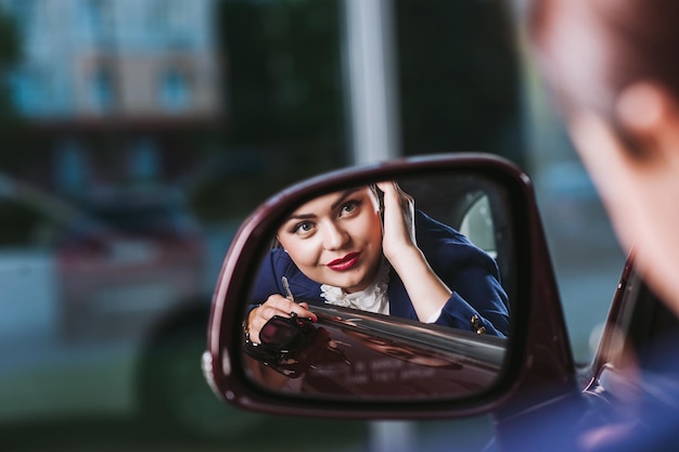 Mooie vrouw weerspiegeld in spiegel van auto