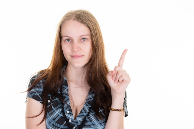 Foto mooie vrouw wijst met de vinger omhoog naar het witte lege ruimtemodel