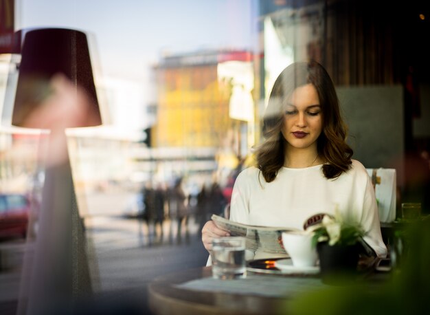 Mooie vrouw zitten in restaurant denken