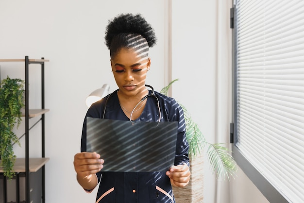 Foto mooie vrouwelijke afrikaanse medische werknemer röntgenstraal te houden