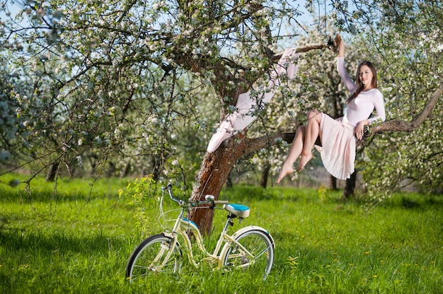 Mooie vrouwelijke fietser met retro fiets in de lente tuin