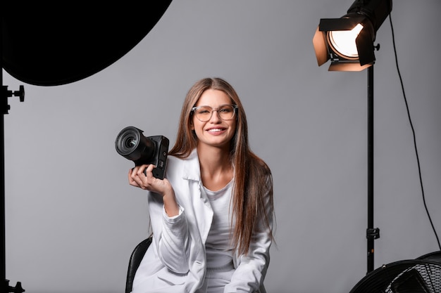 Mooie vrouwelijke fotograaf in studio