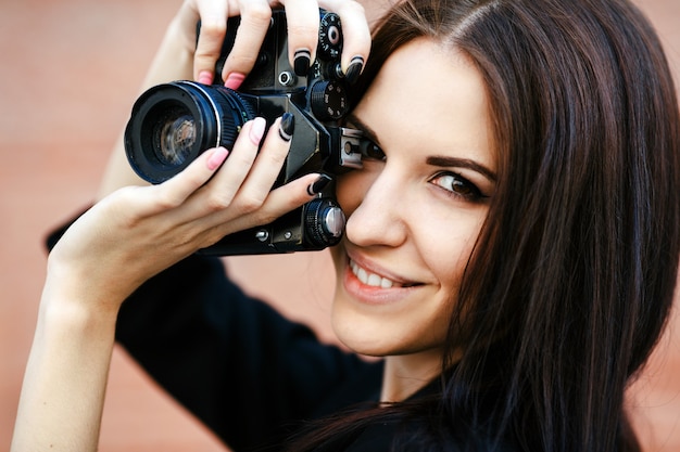 Mooie vrouwelijke fotograaf poseren met camera