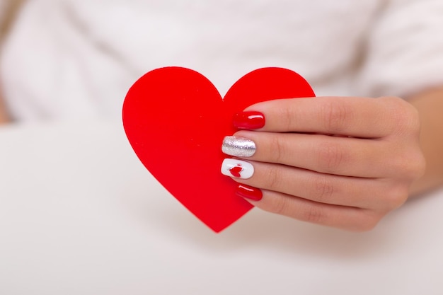 Mooie vrouwelijke hand met romantische manicure nagels met hart Valentijnsdag ontwerp