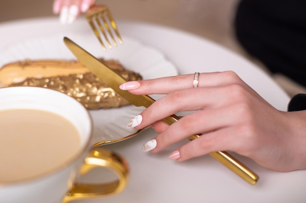 Mooie vrouwelijke handen met luxe manicure nagels met mes en vork