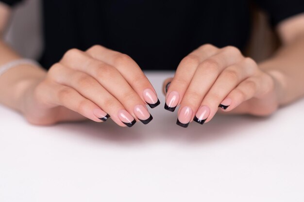 Mooie vrouwelijke handen met mode manicure nagels zwarte gel polish