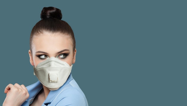 Foto mooie vrouwelijke modemodel met gezichtsmasker op blauwe achtergrond