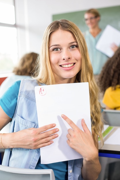 Mooie vrouwelijke student die op papier richt