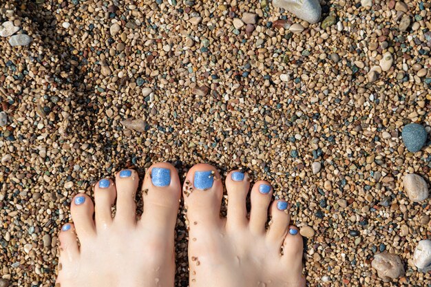 Mooie vrouwelijke voeten met blauwe glitter pedicure