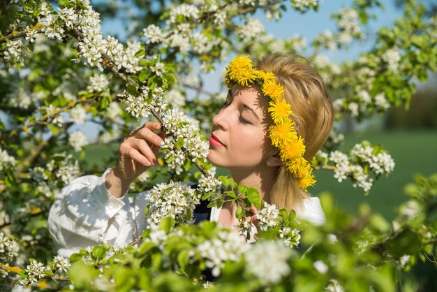 Mooie vrouwelijke vrouw in nationale klederdracht met witte lentebloemen