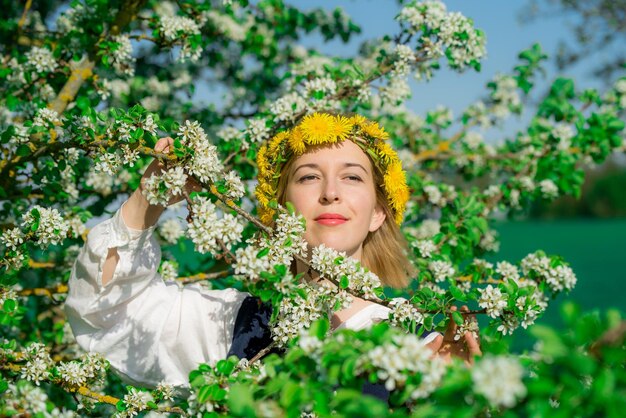 Mooie vrouwelijke vrouw in nationale klederdracht met witte lentebloemen