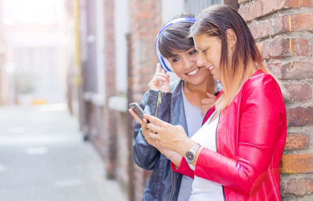 Mooie vrouwen delen informatie met smartphone in de stad