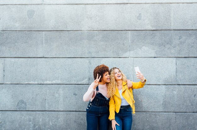 Mooie vrouwen die een zelfportret nemen op de straat. LGTB-concept