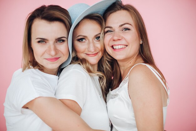 Mooie vrouwen in de zomer kleding hebben veel plezier en viert verjaardag, foto geïsoleerd op roze muur