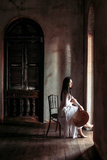 Mooie vrouwen in traditionele klederdracht van Vietnam zaten aan de deur van het huis
