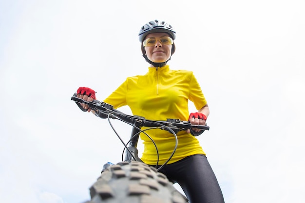 Mooie vrouwenfietser die zich op het wiel van de fiets verheugen. Sport en recreatie. Hobby's en gezondheid.