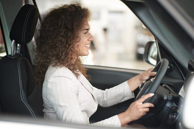 Mooie vrouwenzitting in auto en hand in hand op wiel.