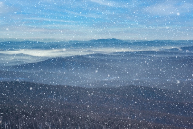 Mooie winter wazig achtergrond van bergen met vallende sneeuw