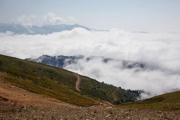 Mooie wolken en mist onder berglandschap.