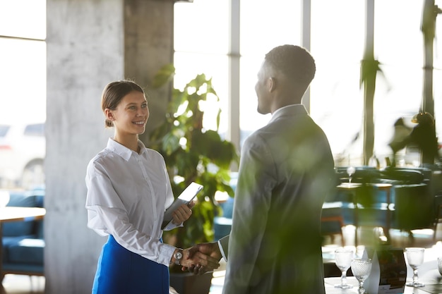 Mooie zakenvrouw die de hand schudt van zakenpartner