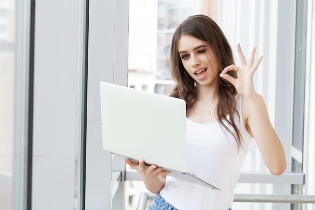 Mooie zakenvrouw die op laptop in heldere, moderne kantoor werkt.