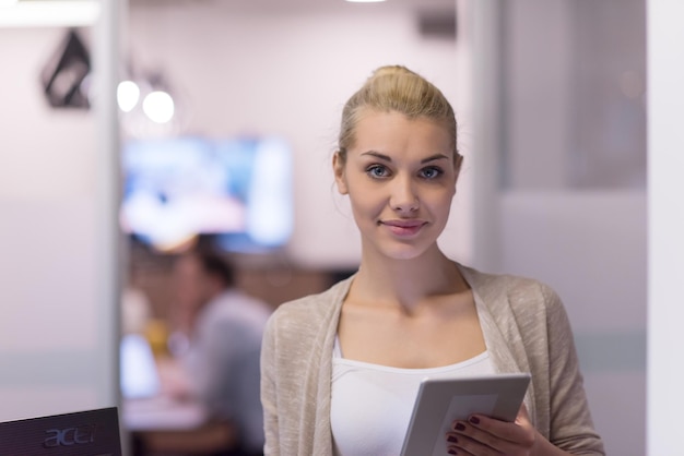 Mooie zakenvrouw met behulp van Tablet voor opstarten Office Interior