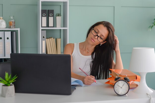 mooie zakenvrouw werkt op kantoor op een laptop freelancer op het werk geeft de leraar les