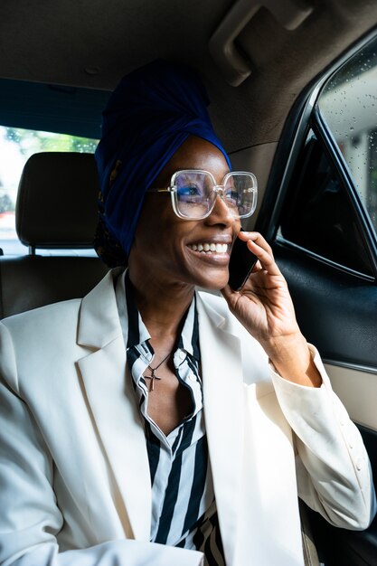 Mooie zakenvrouwen rijden naar de luchthaven en vertrekken voor een werkreis. Smartphone gebruiken om te bellen