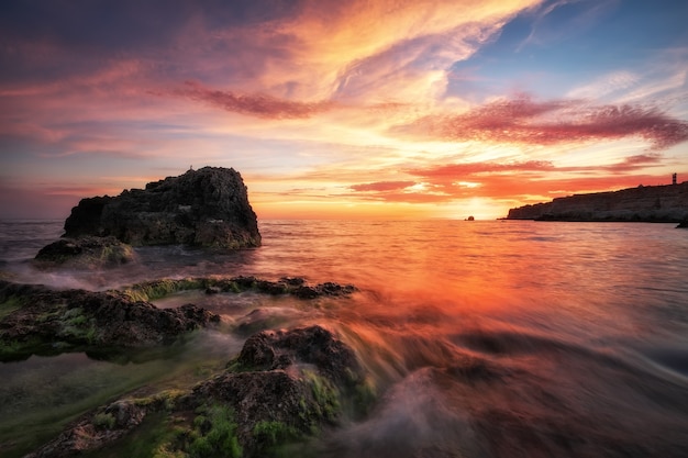 Mooie zomerse landschap met zonsondergang, kleurrijke lucht en zee. Samenstelling van de natuur