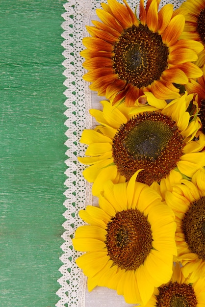 Mooie zonnebloemen in kruik op servet op tafel close-up