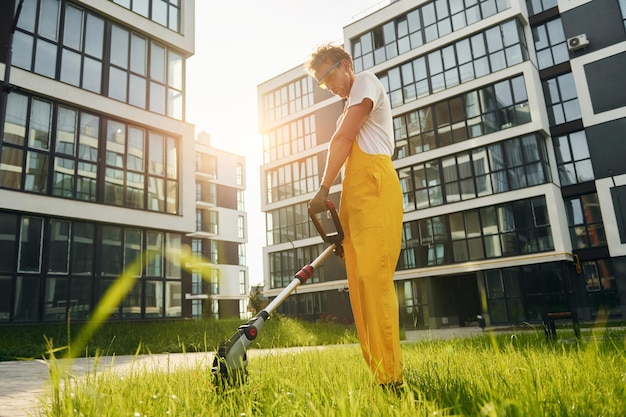 Mooie zonneschijn Man sneed het gras met grasmaaier buiten in de tuin