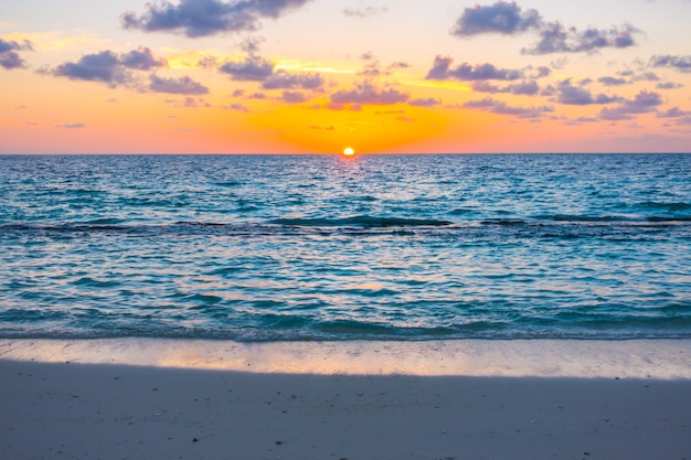 Mooie zonsondergang met hemel over kalme overzees in het tropische eiland van de maldiven.