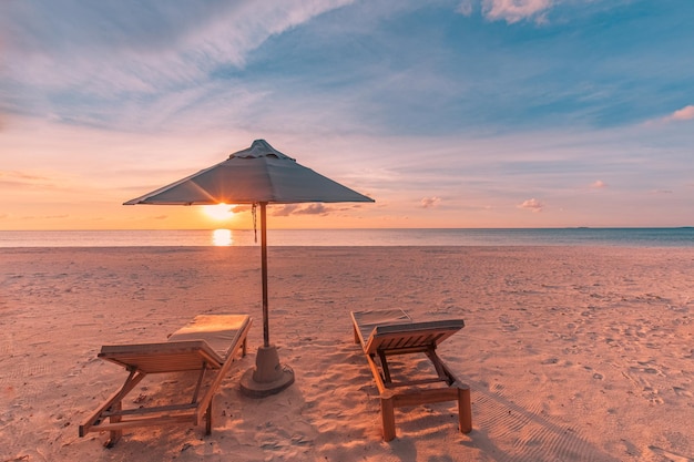 Mooie zonsondergang op het strand Stoelen op het zandstrand bij de zee Romantische zomervakantie en vakantie