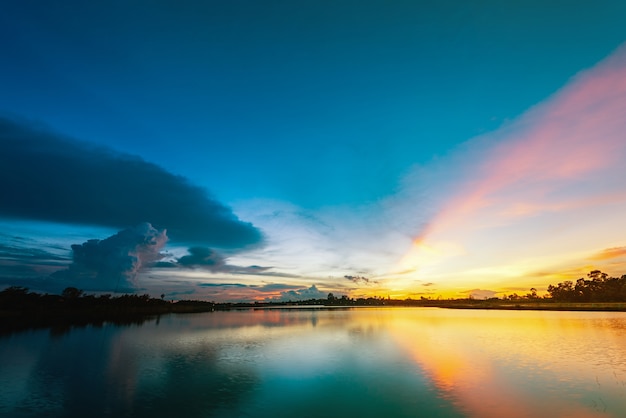 Mooie zonsondergang over meer met blauwe hemel