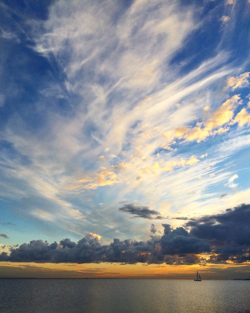 Mooie zonsonderganghemel op de zee of het meer en bootzeiljacht bij zonsondergang prachtig uitzicht op de natuur