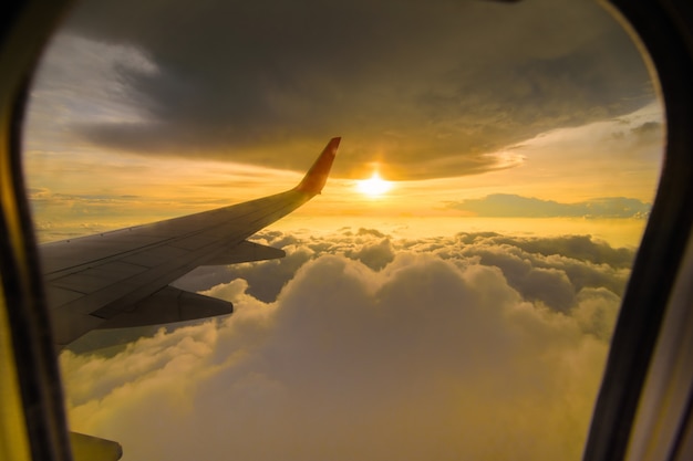 Mooie zonsonderganghemelwolken die door het vliegtuigvenster zien.