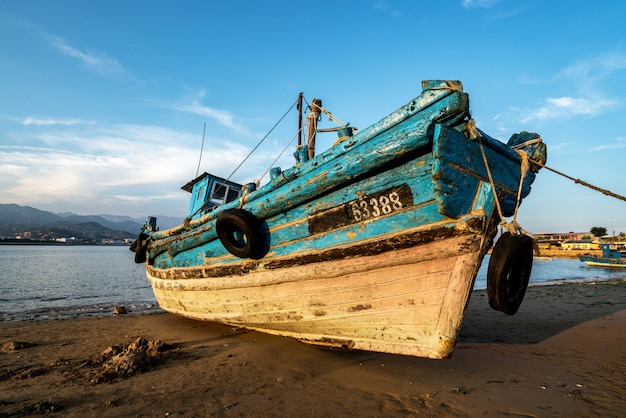 Mooie zonsopgang op een oude houten vissersboot op het strand