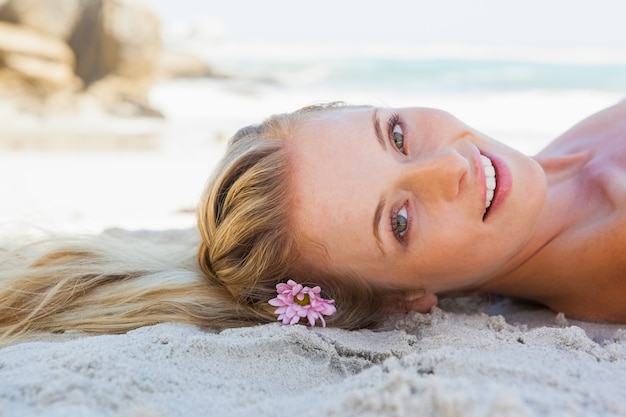 Mooie zorgeloze blonde liggend op het strand